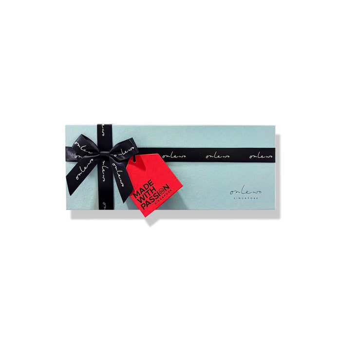 Onlewo 'City in the Garden' silk tie gift box — powder blue velvet box 23.5cm x 9cm x 4cm tied with black Onlewo branded satin ribbon, with story card