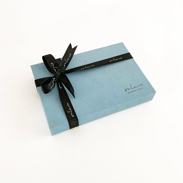 Onlewo 'Peranakan Story' silk pocket square gift box — powder blue velvet box 16cm x 11cm x 2.5cm tied with black Onlewo branded satin ribbon, with story card